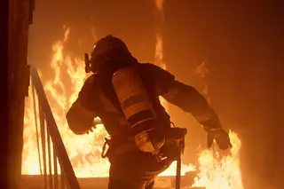 Firefighter entering a burning building, symbolizing urgency and high-stakes action for disability advocates